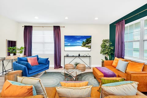 Our jewel toned living room boasts plenty of comfortable seating & a 75" TV
