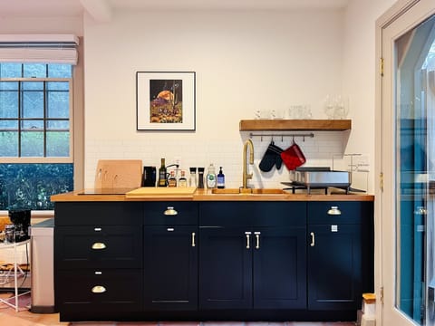1ST FLOOR: Kitchenette with sink, 2-burner induction cooktop and glassware