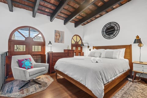 Loft Queen Bedroom · Bright, open space beneath soaring wood-beam ceilings.