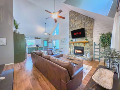 Open concept family room, kitchen with 2 story stacked stone gas fireplace