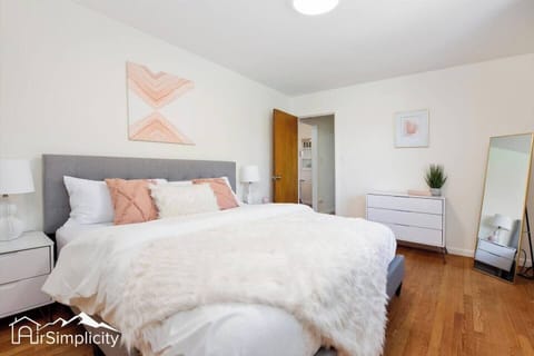 - Cozy king bedroom with soft textures, peachy accents, and calming wall art
- Relax in a plush bed topped with a faux fur throw and supportive pillows
- Stylish white dresser and natural light complete the peaceful retreat
