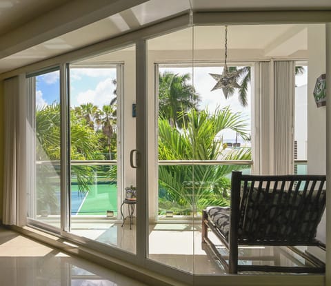 Step into your tropical oasis—bright sunlight, lush palms, and pool views just beyond your glass doors. Relax in modern comfort with direct balcony access to paradise.