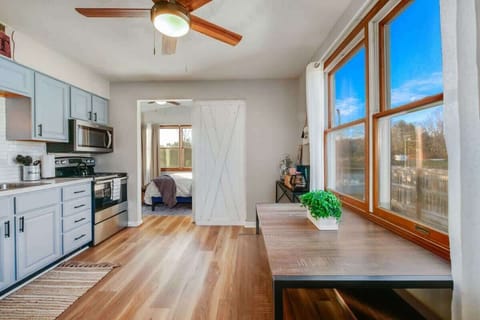 - Dining area with large windows and bright views   - Farmhouse style bench seating for shared meals   - Open layout connected to bedroom and kitchen  