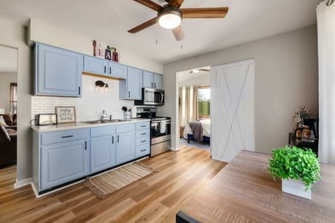 - Modern kitchen with light blue cabinetry design   - Stainless appliances for cooking convenience   - Barn door access leads directly to bedroom  