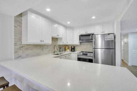 Newly remodeled with stainless steel appliances and peninsula with barstools.
