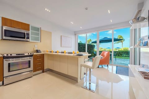 Your modern kitchen opens to stunning sea views through floor-to-ceiling windows, creating the perfect space to prepare meals while gazing at paradise.