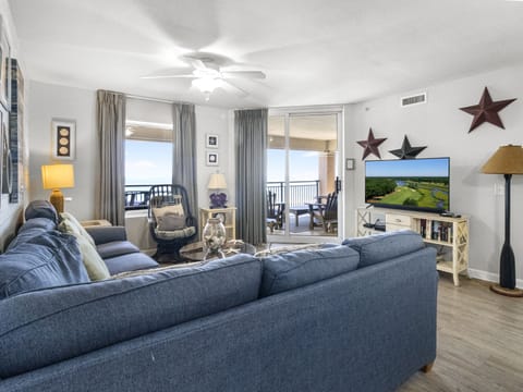 Relax in your stylish living room with plush blue sectional seating, perfect for watching your favorite shows while enjoying natural light.
