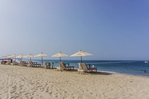 On the beach, white sand, beach umbrellas, beach towels