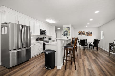 Bright open kitchen with breakfast bar, stainless appliances, and dining space
