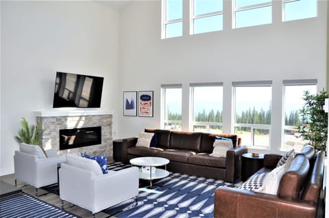 Large, cozy living room features extra high ceilings and unobstructed views