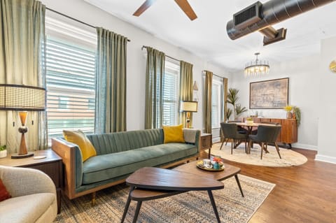 Relax in style in this mid-century inspired living room featuring rich wood tones, chic decor, and abundant natural light — perfect for unwinding after exploring Kansas City.