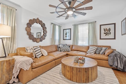 Spacious and stylish living room featuring a large sectional sofa, farmhouse-chic décor, and warm natural light—your cozy Midtown retreat just 0.3 miles from the new Main Street Streetcar and walkable to Westport.
