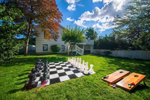 Fenced in backyard with large outdoor chess and firepit. 