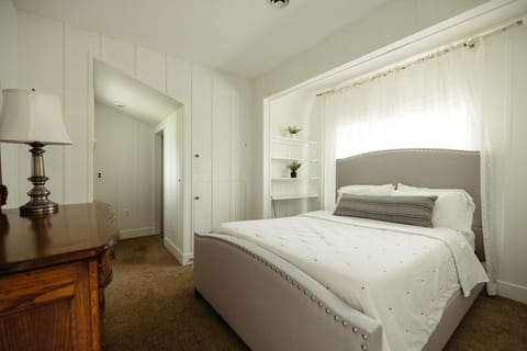 Main floor bedroom includes queen bed and barn door opening into the dining/living room. Bathroom is accessed outside of the room from the living room.
