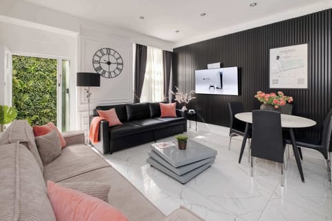 Living Room | Enjoy the spacious luxury of our living room, adorned with high ceilings and an open-plan kitchen for a sense of grandeur. Relax in front of the smart 65-inch TV with a PS5 and stay comfortable with our advanced air conditioning system.