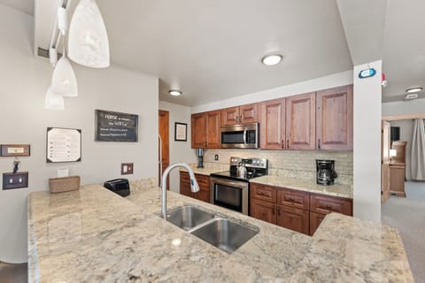 Full size kitchen with stainless steel appliances and granite countertops.