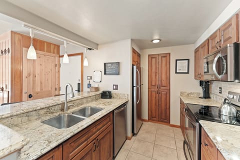 Full size kitchen with stainless steel appliances and granite countertops.