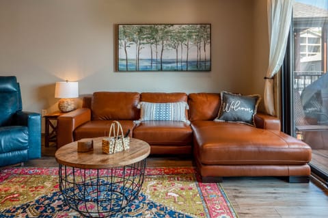 Beautiful seather sectional in the living area with sliding door out to upper deck