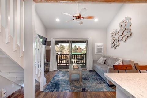 Settle into your stylish living room with vaulted ceilings, modern décor, and a private balcony framing peaceful mountain and forest views—your serene retreat awaits.