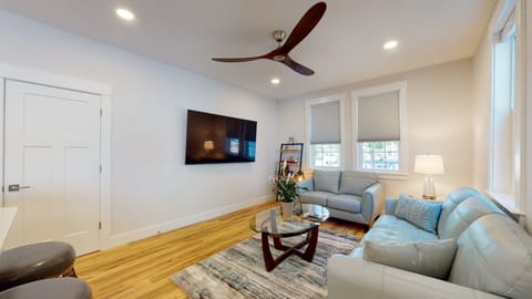 Living room with Samsung 75" OLED smart TV with leather ice-blue couches