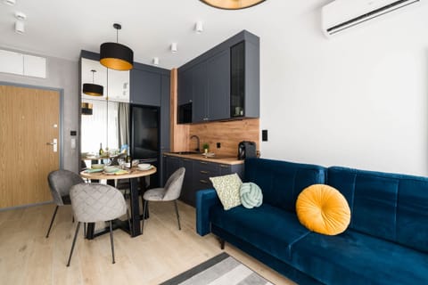 The living area features a sleek dining table and a flat-screen television.