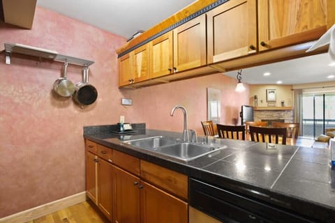 The charming kitchen is equipped with stainless steel appliances, a double basin sink, generous storage space and a convenient pass-through to the nearby dining area.