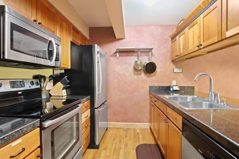 The charming kitchen is equipped with stainless steel appliances, a double basin sink, generous storage space and a convenient pass-through to the nearby dining area.