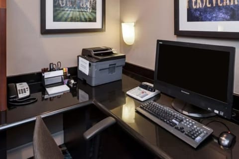 24-hour business center with a desk, computer, and printer — handy for remote work during an extended stay