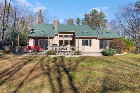 Large backyard, large deck, gas grille, fire pit, patio set and string lights.