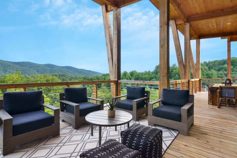 Outdoor living area with a cozy fireplace, plush seating, and mountain views