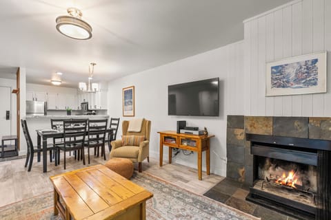 The living room has a wood burning fireplace and flat screen TV.