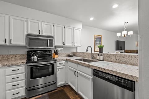 The well-equipped kitchen has stainless steel appliances and white cabinets.