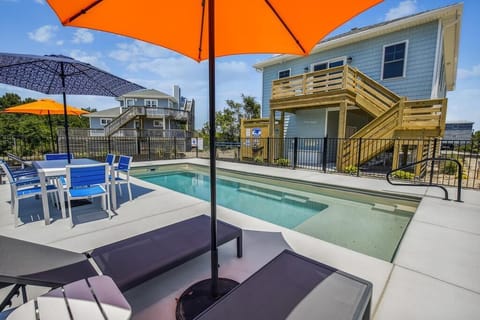 A bright beach house with a private pool awaits, where sunny loungers and shaded dining create your perfect coastal retreat.