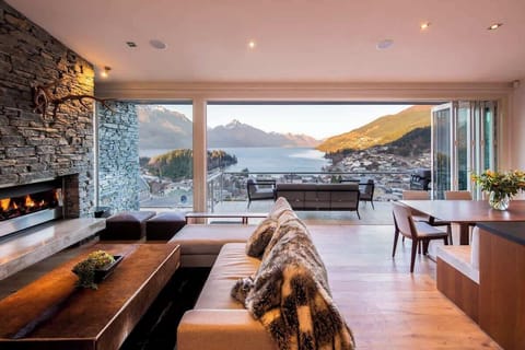 Living Room: Cozy and inviting space with plush seating for six, a gas fireplace, and large windows showcasing stunning lake and mountain views.