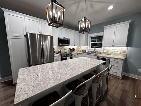 Fully stocked gourmet kitchen with quarts counters and stainless appliances