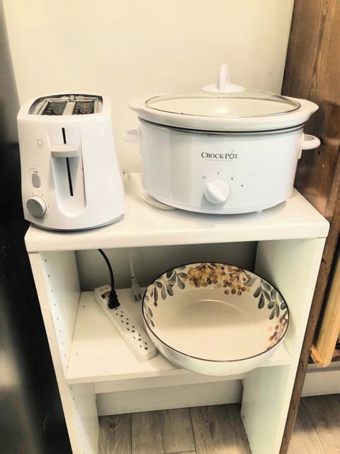 A bread-toaster and a slow cooker in a kitchenette