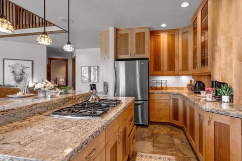 Fully Equipped Kitchen with gorgeous stone countertops, stainless steel appliances, private deck access, and island seating for 3