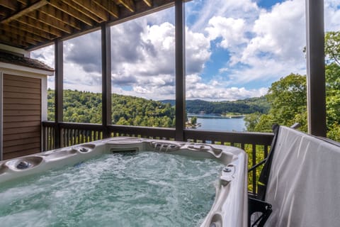 Private deck off of the primary bedroom with hot tub overlooking Lake Glenville