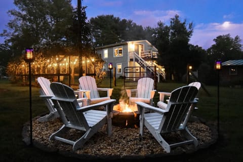 Fire pit w/custom built polywood Adirondack chairs, solar tiki torches, grapevine arbor + Moonflower Cottage behind it