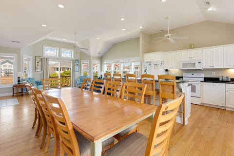 A large island features bar seating for 5 while the dining room has seating for 10 around the table with additional chairs nearby if needed.
