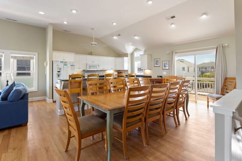 A large island features bar seating for 5 while the dining room has seating for 10 around the table with additional chairs nearby if needed.