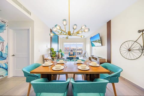 Gather around this stunning dining table where meals become memories. The modern chandelier and coastal décor set the scene for unforgettable evenings with loved ones.