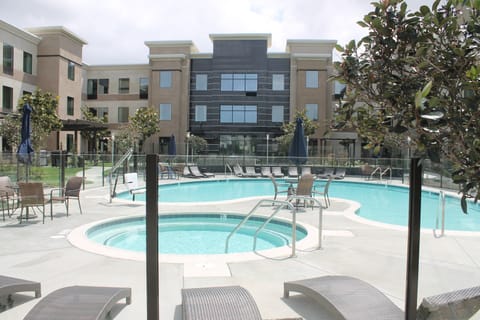 Outdoor pool with hot tub and lounge seating.