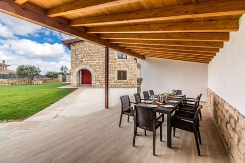 Covered patio with dining area for eight and views of the lush garden.