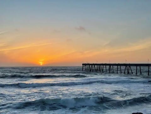 The sunset ocean view next to the pier.