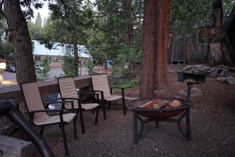 Shared firepit area has a bar top, chairs, firepit, and charcoal BBQ's