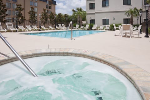 Relax in the bubbling hot tub, just a step from the refreshing pool in a sunny courtyard.