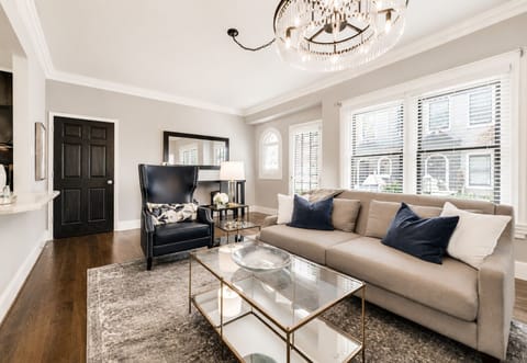 Bright Living Room with Workspace – Sun-filled space featuring a sleek sectional, elegant accents, and a dedicated desk area for working or unwinding in style.