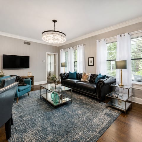 The spacious living room is designed for comfort, featuring a cozy  leather sofa, stylish decor  making it the perfect spot to relax or socialize after a day of exploring.