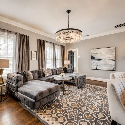 Extra large sofa that overlooks  counter seating in a spacious, bright living room that seamlessly flows into the open-plan kitchen, creating an inviting and airy atmosphere.